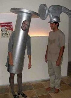 two men standing next to each other in front of a metal thing that looks like a head