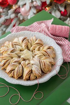 a white plate topped with pastry next to a christmas tree