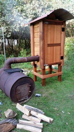 a large barrel sitting on top of a lush green field next to a pile of wood