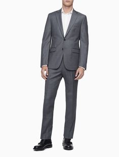 A refined look with tailored, slim fit shaping, this Calvin Klein blazer jacket is made with four-season wool and a subtly textured design. Lightly padded shoulders, notch lapels, a 2-button front, 4-button cuffs and multiple front pockets finish this timeless yet modern look. Slim Fit Tuxedo Blazer For Office, Slim Fit Tuxedo Style Blazer For Office, Professional Slim Fit Blazer For Office Wear, Modern Fitted Suits For Fall, Fitted Timeless Suits For Office Wear, Timeless Fitted Suits For Office Wear, Modern Fitted Fall Suit, Elegant Structured Business Suits, Fitted Structured Tuxedo Suit