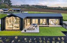 an aerial view of a modern home in the country side with grass and lawn area