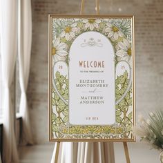 a welcome sign with flowers on it in front of a brick wall and white curtains