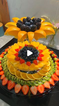 a cake made to look like a sunflower with fruit on top and flowers in the middle