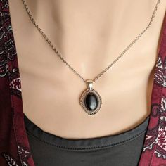 "This Obsidian necklace features a richly polished black Obsidian cabochon set in an elegant oval pendant. The vintage-inspired pendant has lovely flourish designs. The combination of the silver pendant and inky black stone is beautiful. For those that follow Crystal beliefs: Obsidian is believed to be truth-enhancing. A strongly protective stone, people believe it forms a shield against negativity. Did you know that Obsidian is volcanic glass? It is classified as Igneous rock. This would be a q Obsidian Ring, Obsidian Necklace, Jewelry Gothic, Victorian Pendants, Obsidian Stone, Vintage Inspired Jewelry, Crystal Necklaces, Jewelry Black, Onyx Earrings