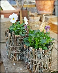 two wooden planters with flowers in them sitting on a table