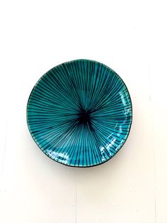 a blue plate sitting on top of a white wall