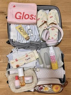 an open suitcase filled with baby items on top of a wooden floor