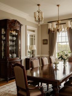 a dining room table with chairs and a china cabinet in front of the large window