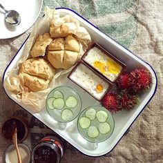 an assortment of food on a plate with spoons and sauces next to it