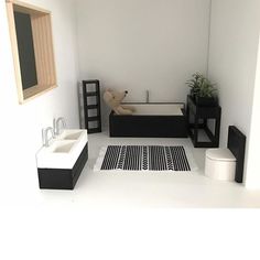 a white bathroom with black and white decor on the floor, sink and bathtub