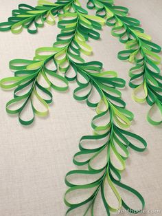 some green paper leaves on a white surface