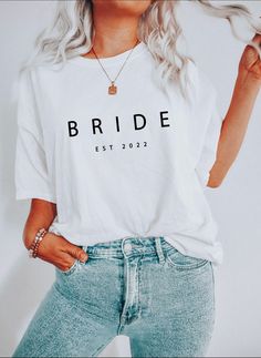 a woman with blonde hair wearing a white t - shirt that says bride on it