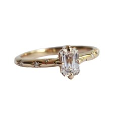 This stunning Stella Starburst Ring is crafted with a unique north/south prong setting and features an Emerald-cut stone of your choice, a lab-grown diamond, or lab-created moissanite, complemented by a unique starburst pattern on the band. Crafted with precision and care, this classic yet modern design makes it a unique engagement ring, and an ideal gift for any occasion. MAIN STONE： Choice of Lab-Created Moissanite (FAB Moissanite) DEF color Lab-Grown Diamond (HPHT or CVD) VS2 clarity or bette Starburst Cut Engagement Ring, Modern Classic Wedding Ring, Emerald With Pear Side Stones, Diamond Embedded Ring, Engagement Rings Cool, Oval Gemstone Engagement Ring, Engagement Ring Engraved Band, Vintage 3 Stone Engagement Rings, Starbrite Cut Engagement Ring