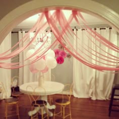 a white table topped with pink and white balloons