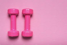 two pink dumbbells on a pink background