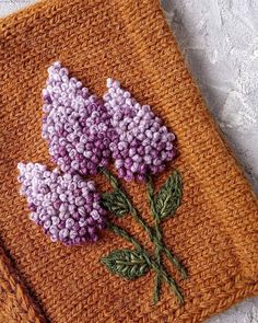 a close up of a knitted object with flowers on it