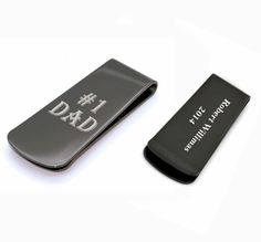 two black and silver business card holders on a white surface, one with the word dad printed on it