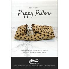 a dog laying on top of a bed covered in a blanket with paw prints and the words puppy pillow