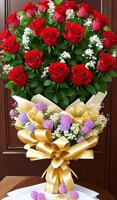 a bouquet of red roses sitting on top of a table