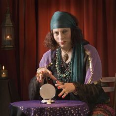 a woman sitting at a table in front of a plate with an object on it