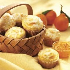 a basket filled with muffins next to oranges