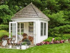 a small white gazebo sitting on top of a lush green field