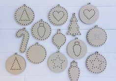 wooden cutout ornaments are arranged on a white surface with holes in the shape of letters and numbers