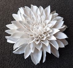 a large white flower sitting on top of a carpet