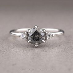 a white gold ring with an oval cut diamond surrounded by smaller round diamonds