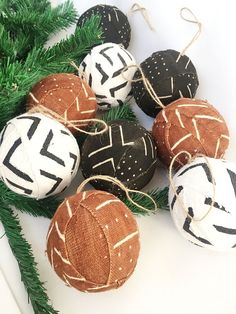 some ornaments are sitting on the table next to a christmas tree and pine branches with twine