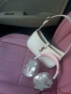 the inside of a car with pink leather seats and silver ornaments hanging from it's center console