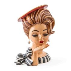 a ceramic figurine of a woman with her hand on her chin