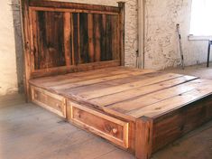 a bed made out of wooden planks in a room with brick walls and flooring