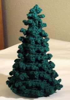 a crocheted christmas tree sitting on top of a bed