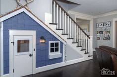 the dog house is painted blue and has a white staircase leading up to it's second floor