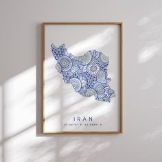 a blue and white map of the country of iraq is shown in a wooden frame