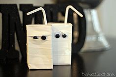 two paper bags with eyes and noses are sitting next to each other on a table