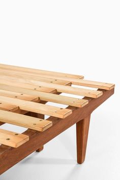 a wooden bench made out of plywood planks on a white background with no one around it