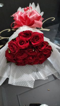 a bouquet of red roses sitting on top of a table