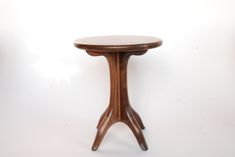 a small wooden table sitting on top of a white floor