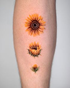 the sunflowers are painted on the legs of someone's body, and they appear to be different colors