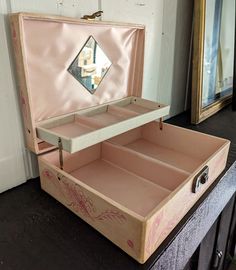 an open pink suitcase sitting on top of a black table next to a mirror and door