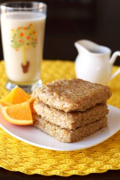 some cookies and orange slices are on a white plate next to a glass of milk