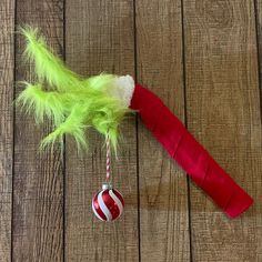 a red and white candy cane on top of a wooden table next to a christmas ornament