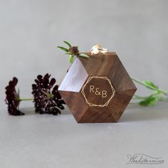 a wooden ring box with the initials r & b on it next to some flowers