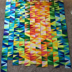 the colorful quilt is laid out on the floor