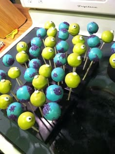 there are many green and blue cake pops on the stove with googly eyes painted on them