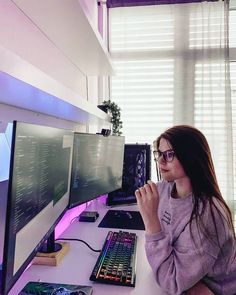 a woman sitting in front of a computer monitor with a keyboard and mouse on it