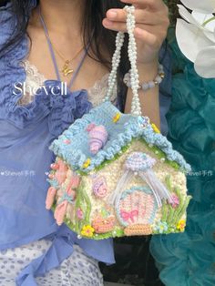 a woman is holding a small purse made out of crochet and bead