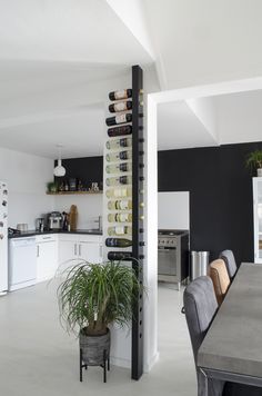 a dining room table with chairs and a wine rack on the wall in front of it